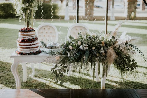 White Flowers and Green Leaves on White Wooden Table