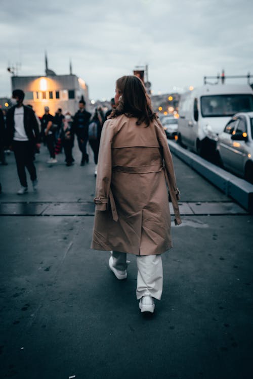 Woman in Brown Coat Walking on the Road