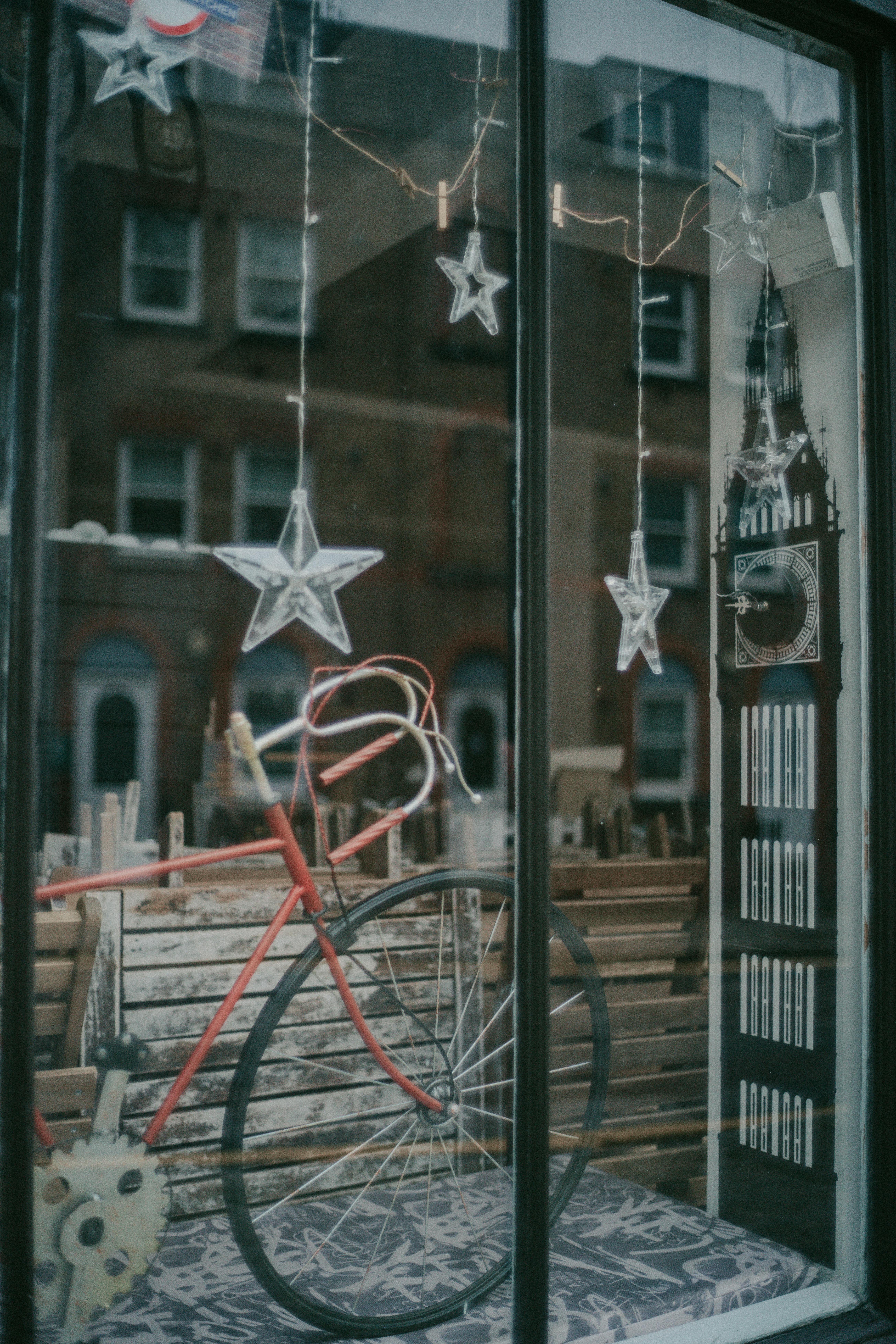 A festive store window display featuring a vintage bicycle and star-shaped decorations, perfect for holiday shopping inspiration.