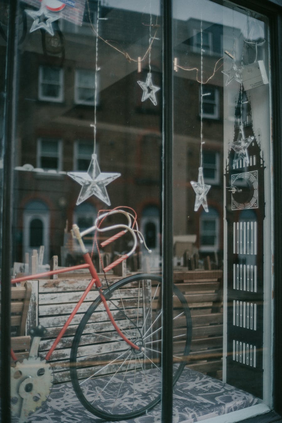 A festive store window display featuring a vintage bicycle and star-shaped decorations, perfect for holiday shopping inspiration.