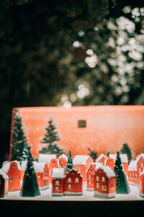 Free Miniature Christmas village with decorations under soft lighting, evoking holiday cheer. Stock Photo