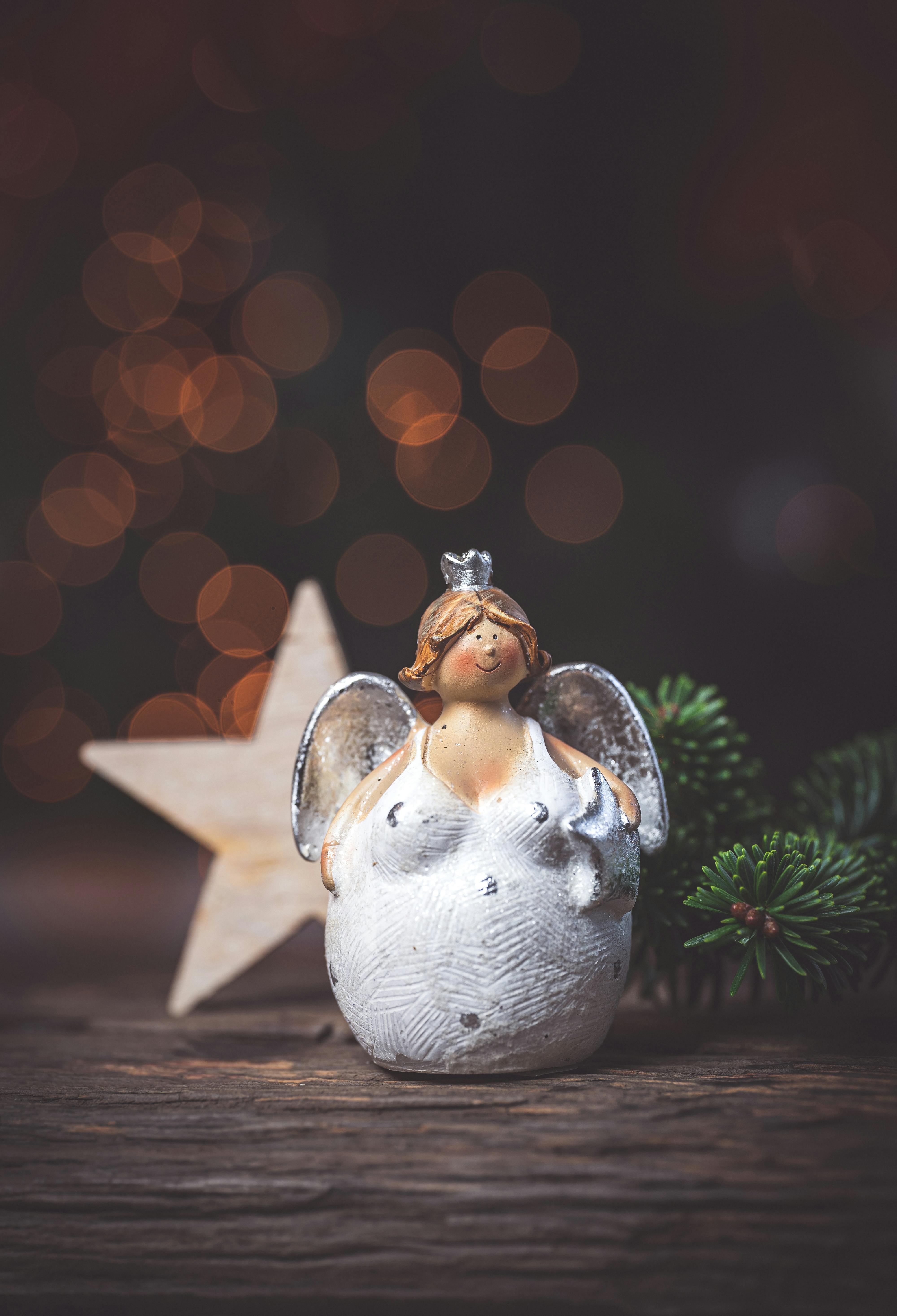 Festive angel ornament with sparkling bokeh and star, perfect for holiday decor.