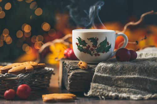 Free A cozy scene with a steaming cup, gingerbread cookies, and holiday decorations. Stock Photo