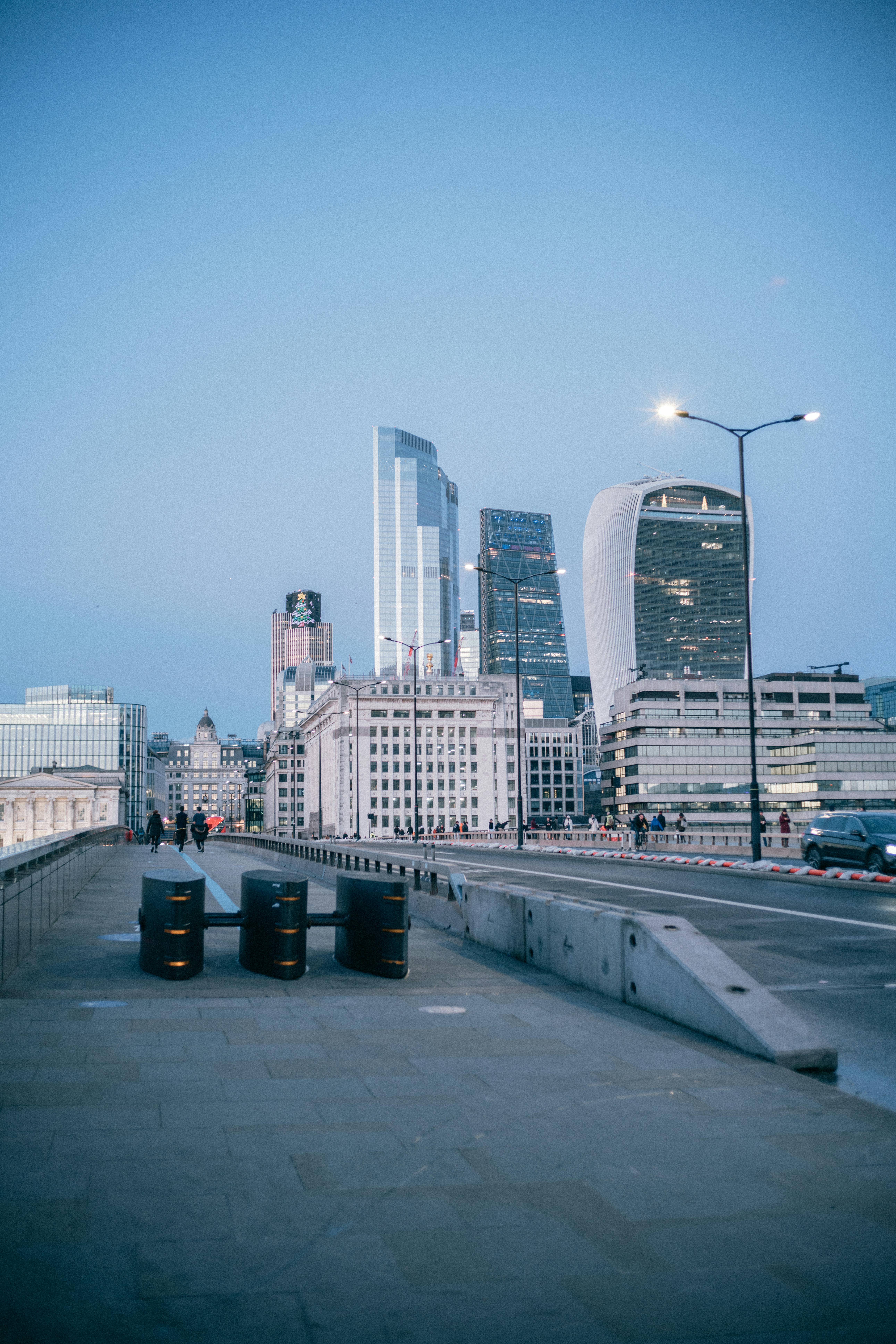 A serene cityscape view showcasing modern skyscrapers along a pedestrian-friendly street at dusk.