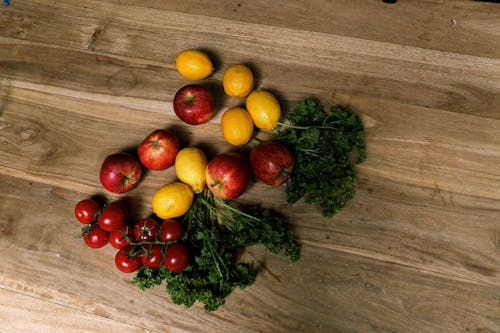Free Red and Yellow Round Fruits on Brown Wooden Table Stock Photo