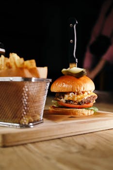 Delicious gourmet burger with fries on a wooden board, ideal for food presentations.