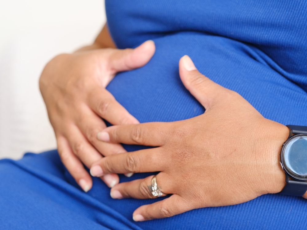 Pregnant woman with hands on her belly