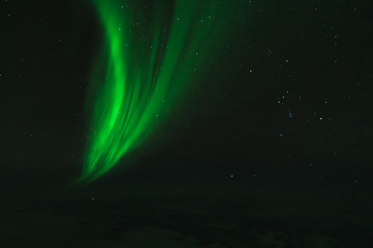 Breathtaking view of green aurora borealis dancing in a starry night sky.