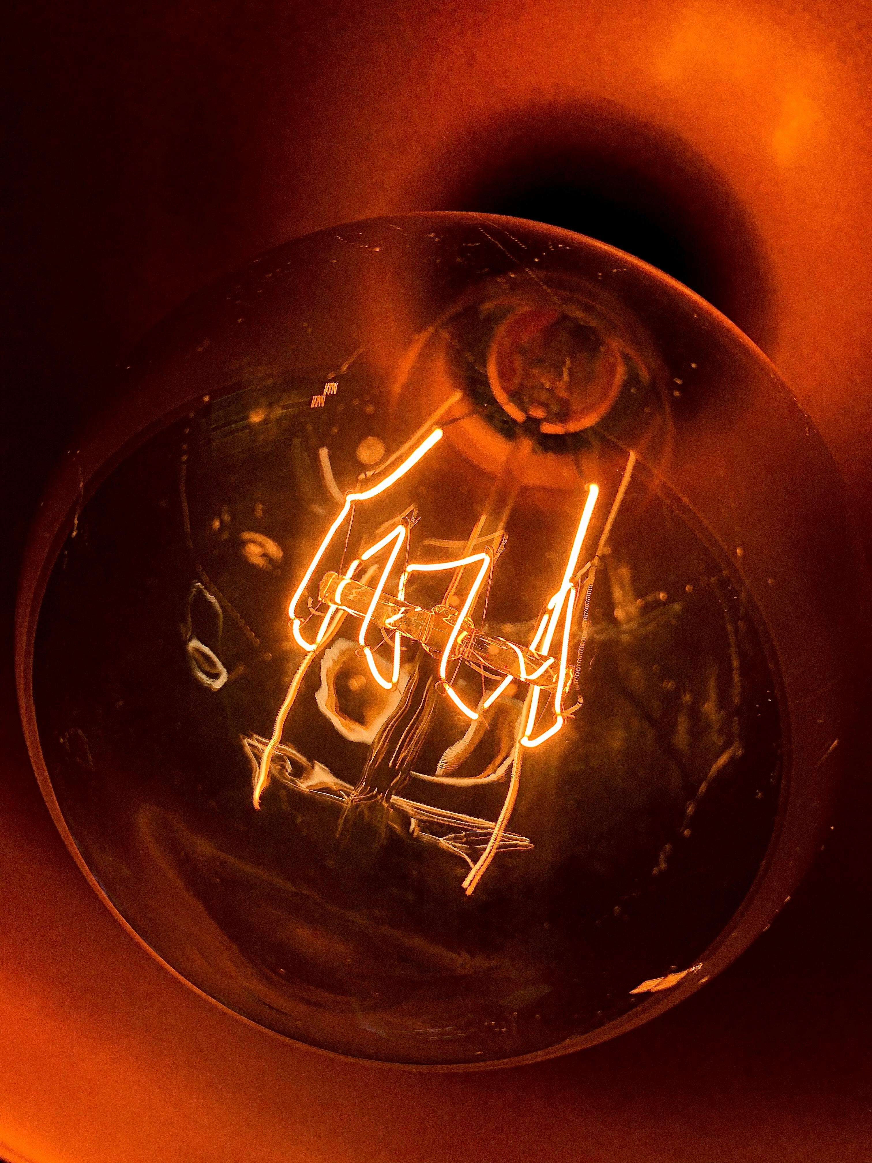 Close-up of a glowing light bulb showcasing intricate filament details.
