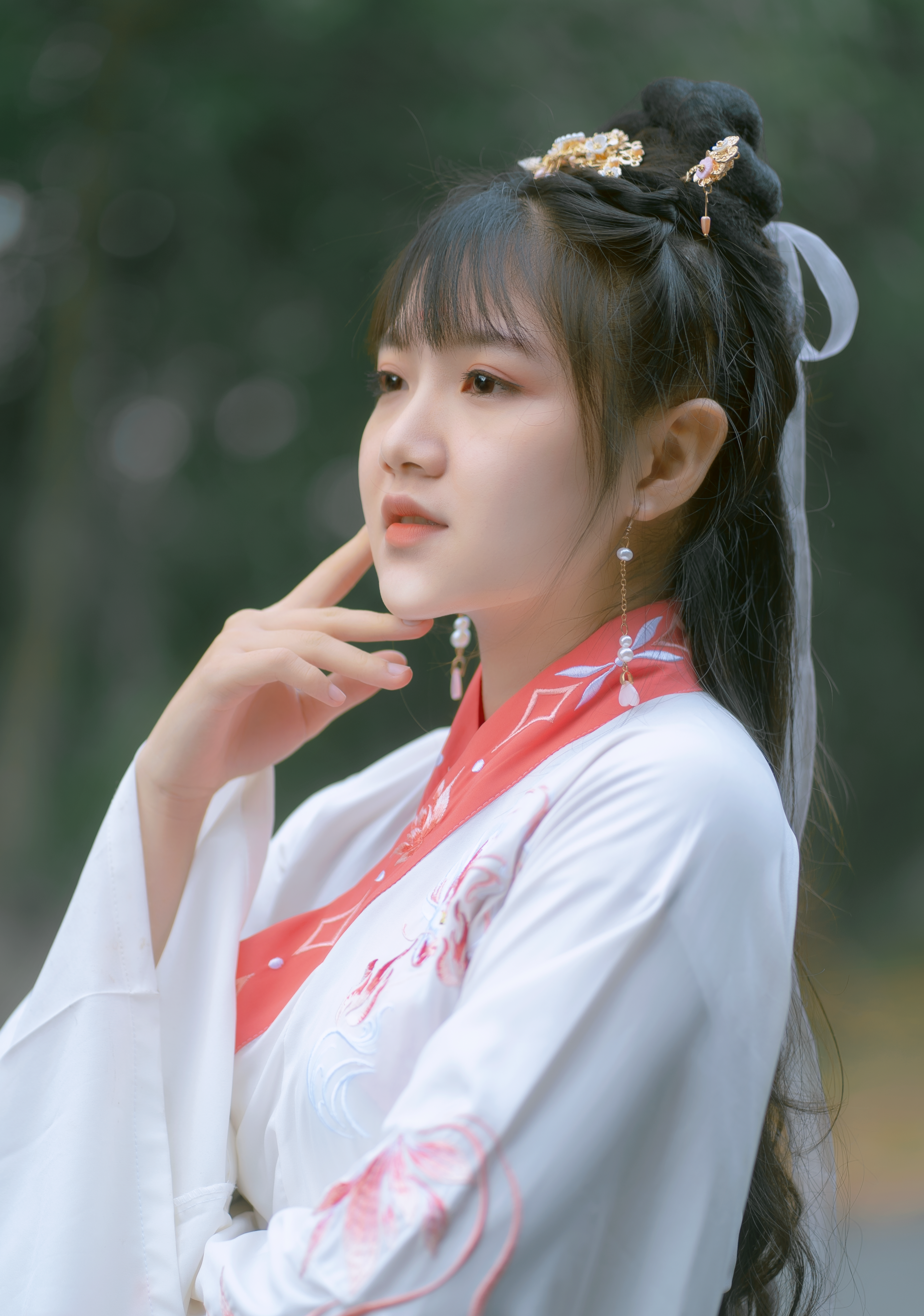 Close-up portrait of an Asian woman in traditional attire, looking contemplatively into the distance.