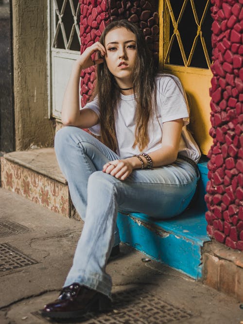 Free Woman in White Shirt Sitting on a Step Stock Photo