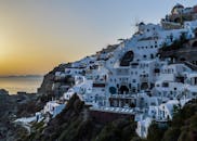 在日落时分探索圣托里尼岛标志性的悬崖建筑，捕捉其宁静之美与如画魅力