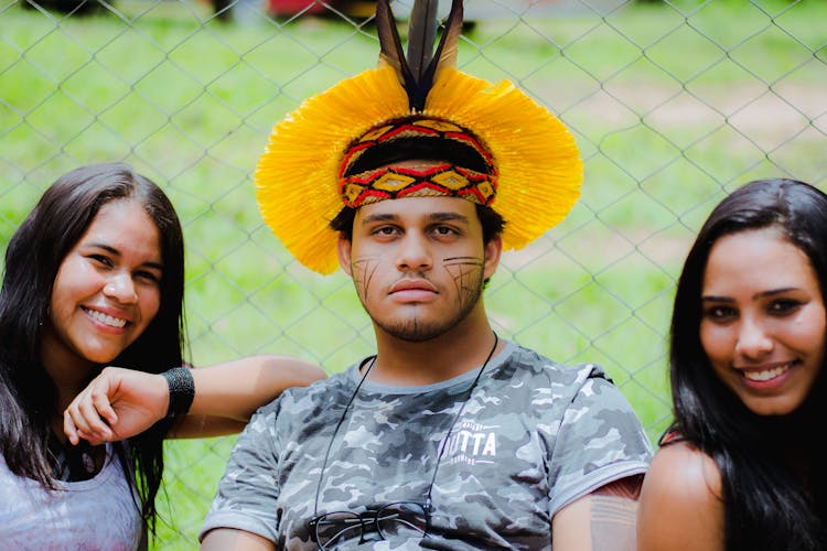 Women Posing With Man In Traditional Hat