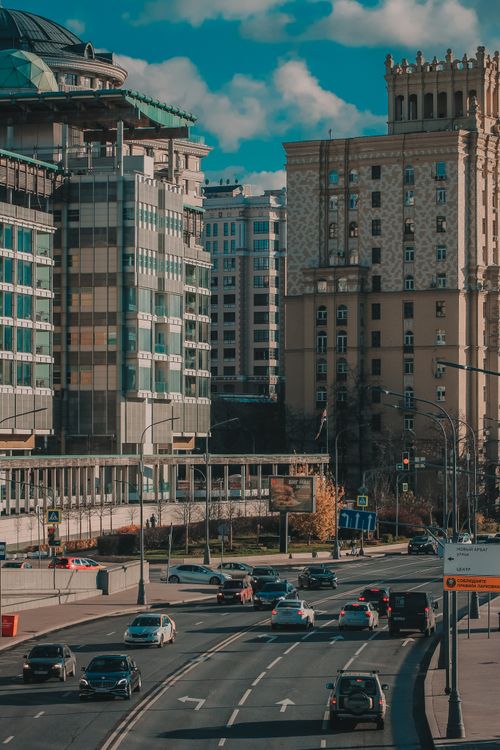 Free A bustling urban cityscape showing traffic and modern architecture under a bright sky. Stock Photo