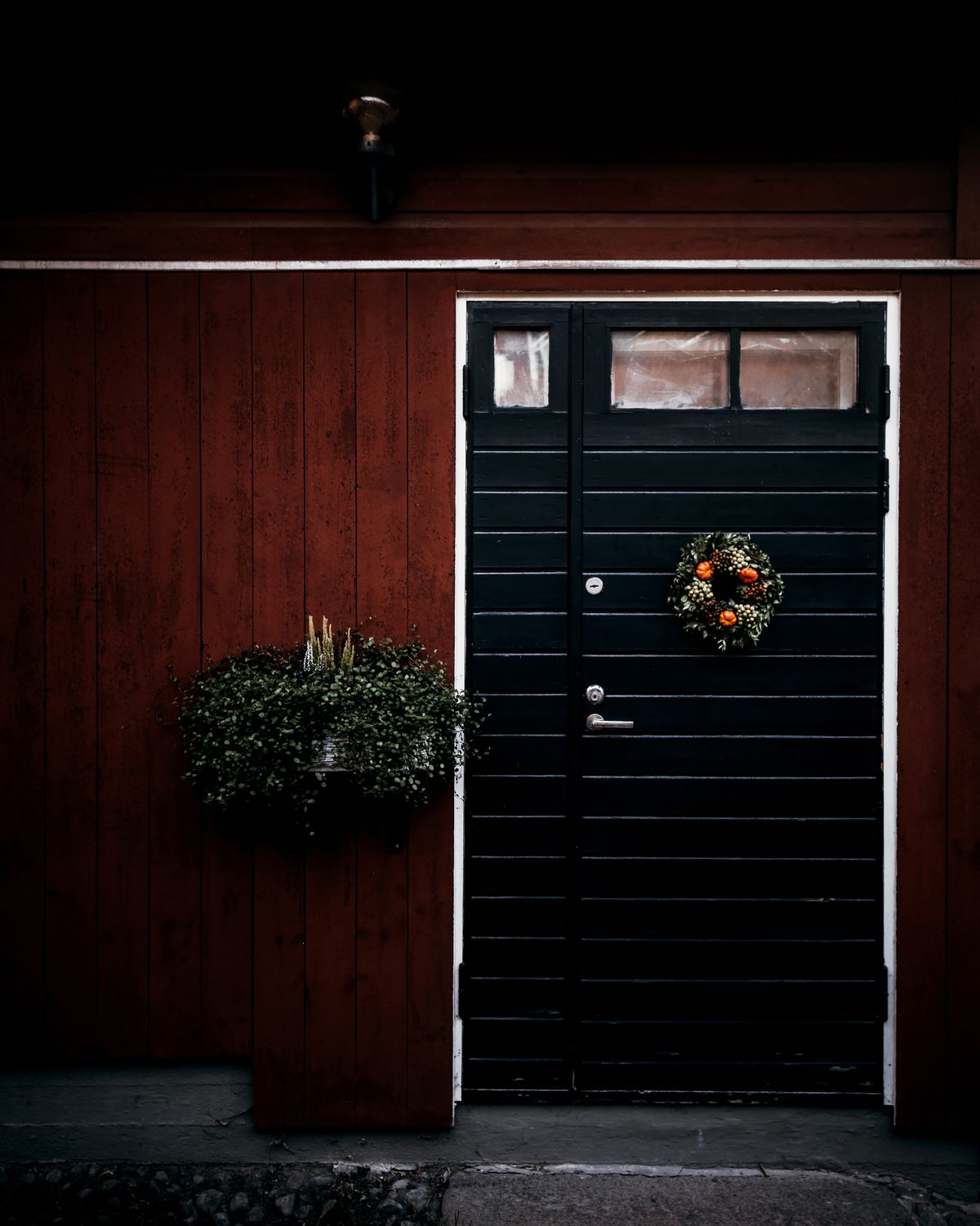 Small dark minimal wreath on a black front door