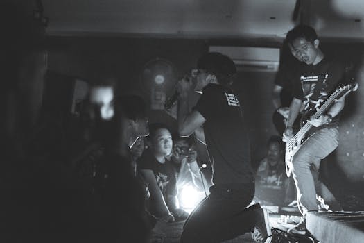 Energetic black and white photo capturing a live band performance with an enthusiastic audience.