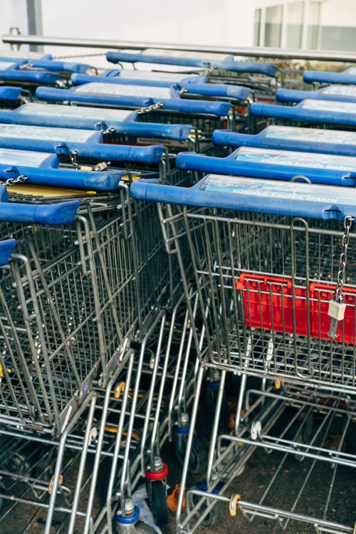 Free A collection of metal shopping carts with blue handles outside a store. Stock Photo