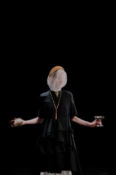 Artistic portrait of a veiled woman holding cup and bread with dark background.
