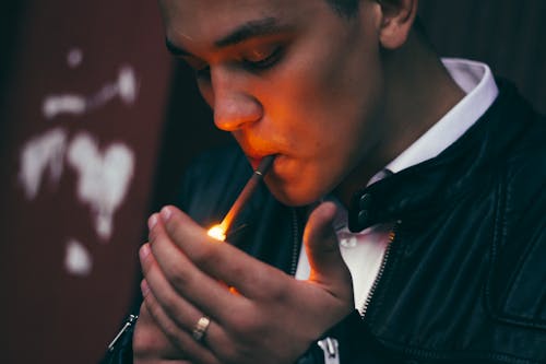Free Man in Black and White Suit Lighting Cigarette Stock Photo