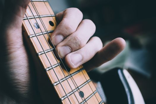 Detailed view of a musician's hand playing chords on an electric guitar fretboard.. detailed, view, musicians