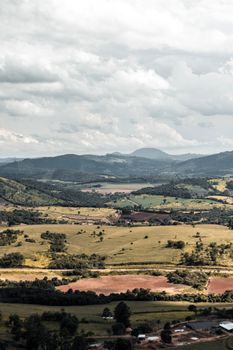 Aerial view of lush rolling hills under an overcast sky, depicting serene countryside.