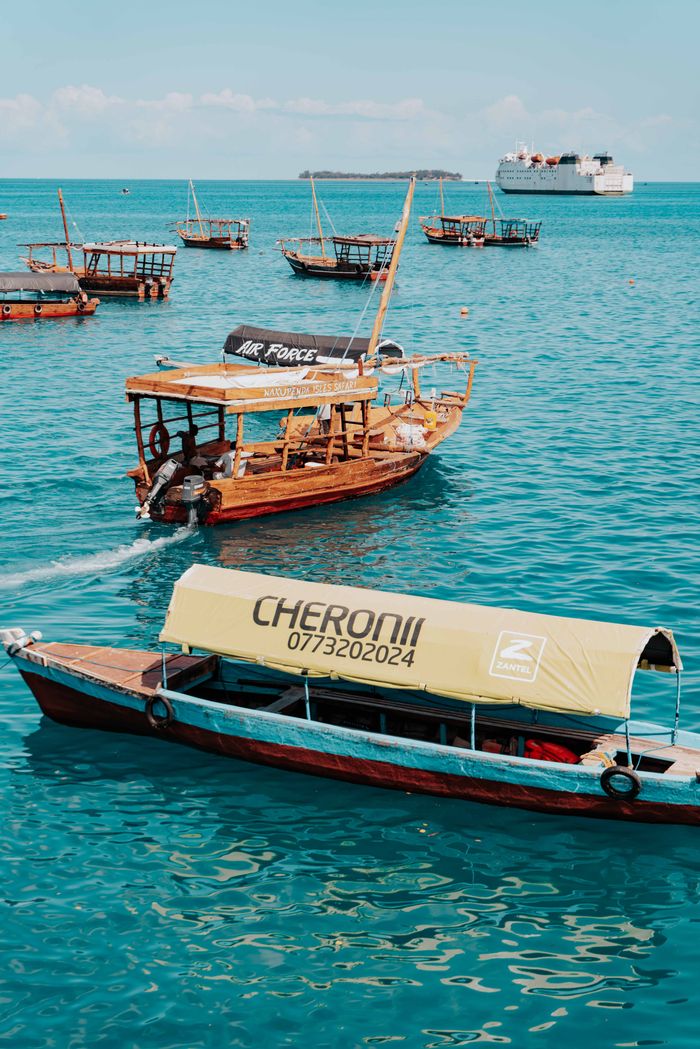Traditional wooden boats floating in the vibrant blue waters of Zanzibar