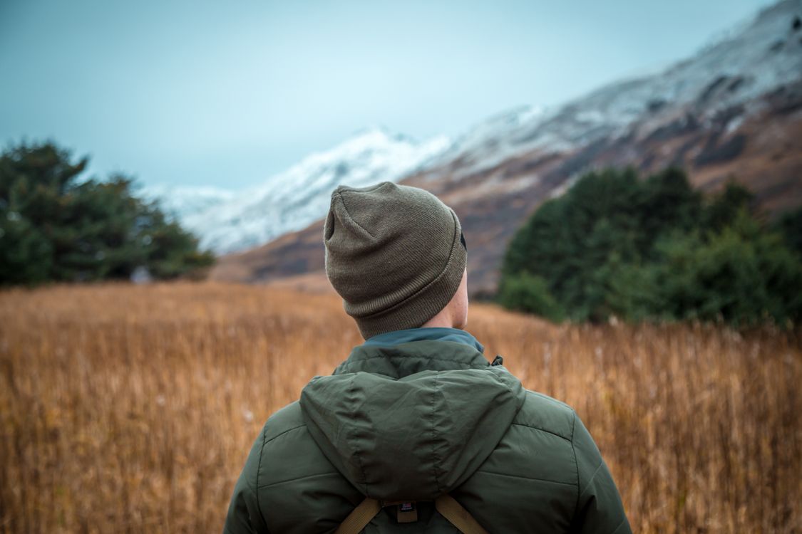 Person Wearing Beanie and Hoodie Standing on Grass Field · Free Stock Photo