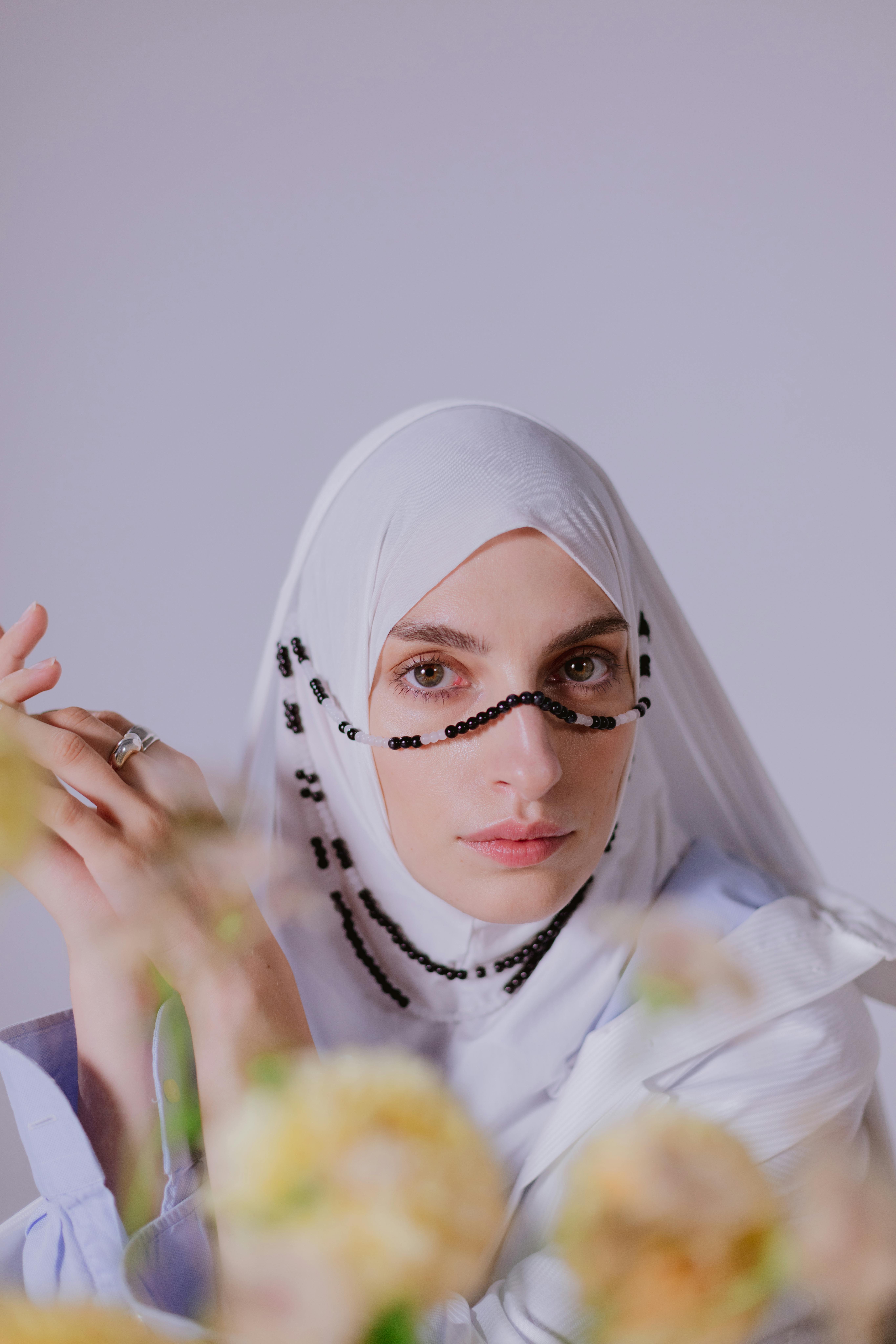 Stunning portrait of a young woman wearing a hijab and beaded accessory, representing traditional elegance.
