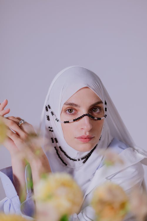 Woman in White Hijab with a Black and White Accessory on Face