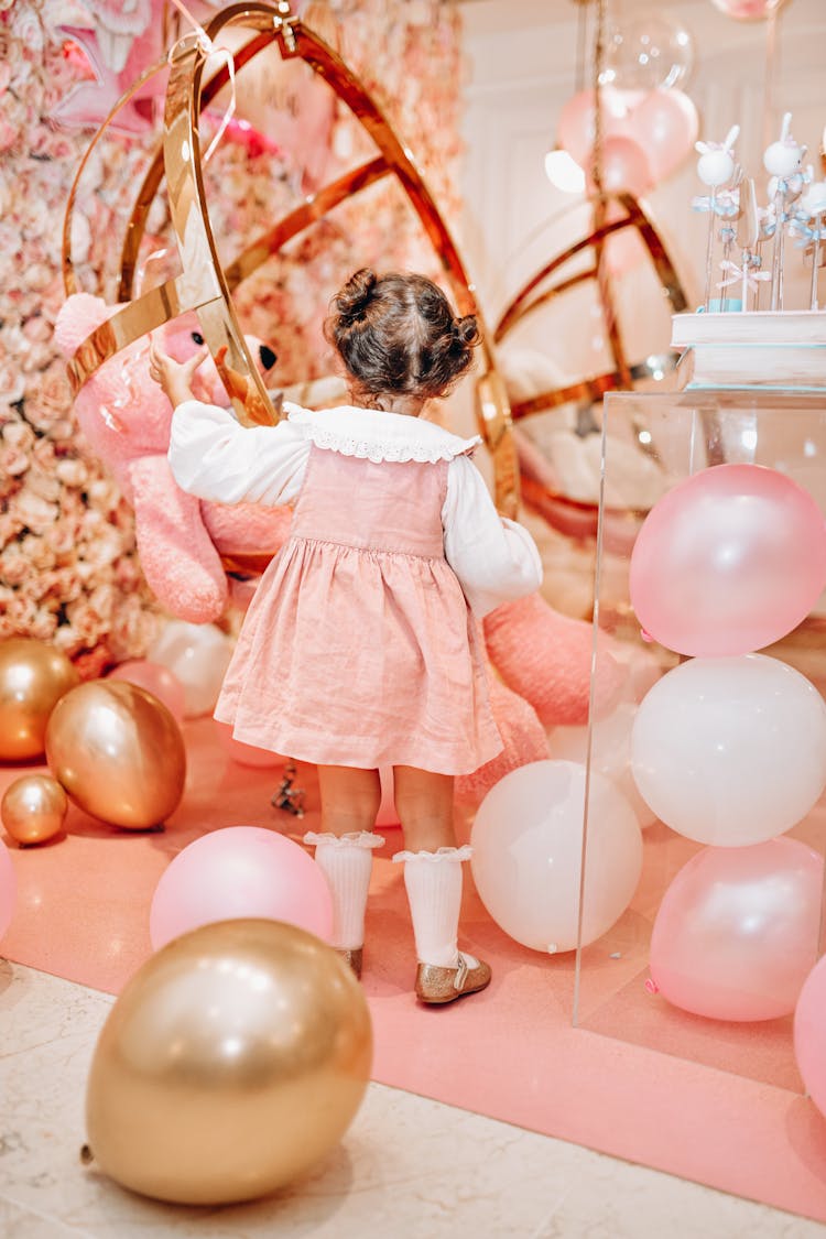 Small Girl Playing With Balloons At Party