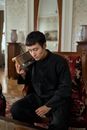 Adult Man Holding Transistor Radio by Ear and Listening Intently