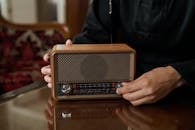 Unrecognizable Male Hand Putting Up Volume on Transistor Radio