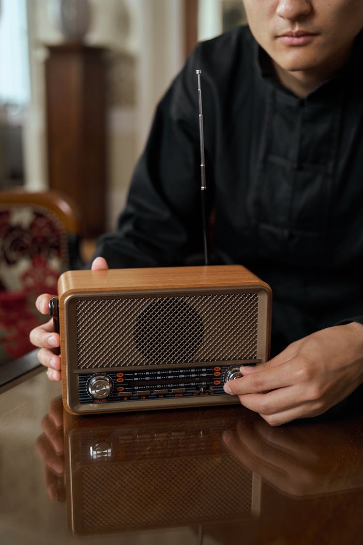 Unrecognizable Man Turning Knob Of Retro Transistor Radio