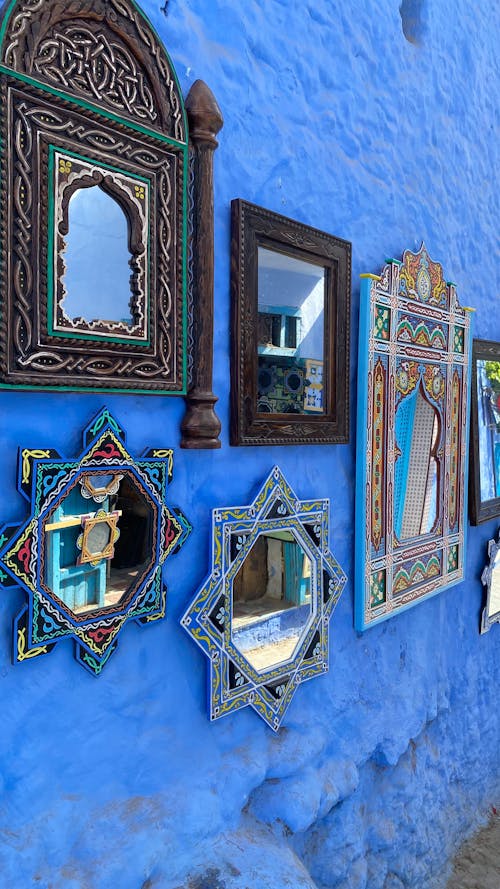Free Decorative Wall Mirrors Hanging on a Blue Wall Stock Photo