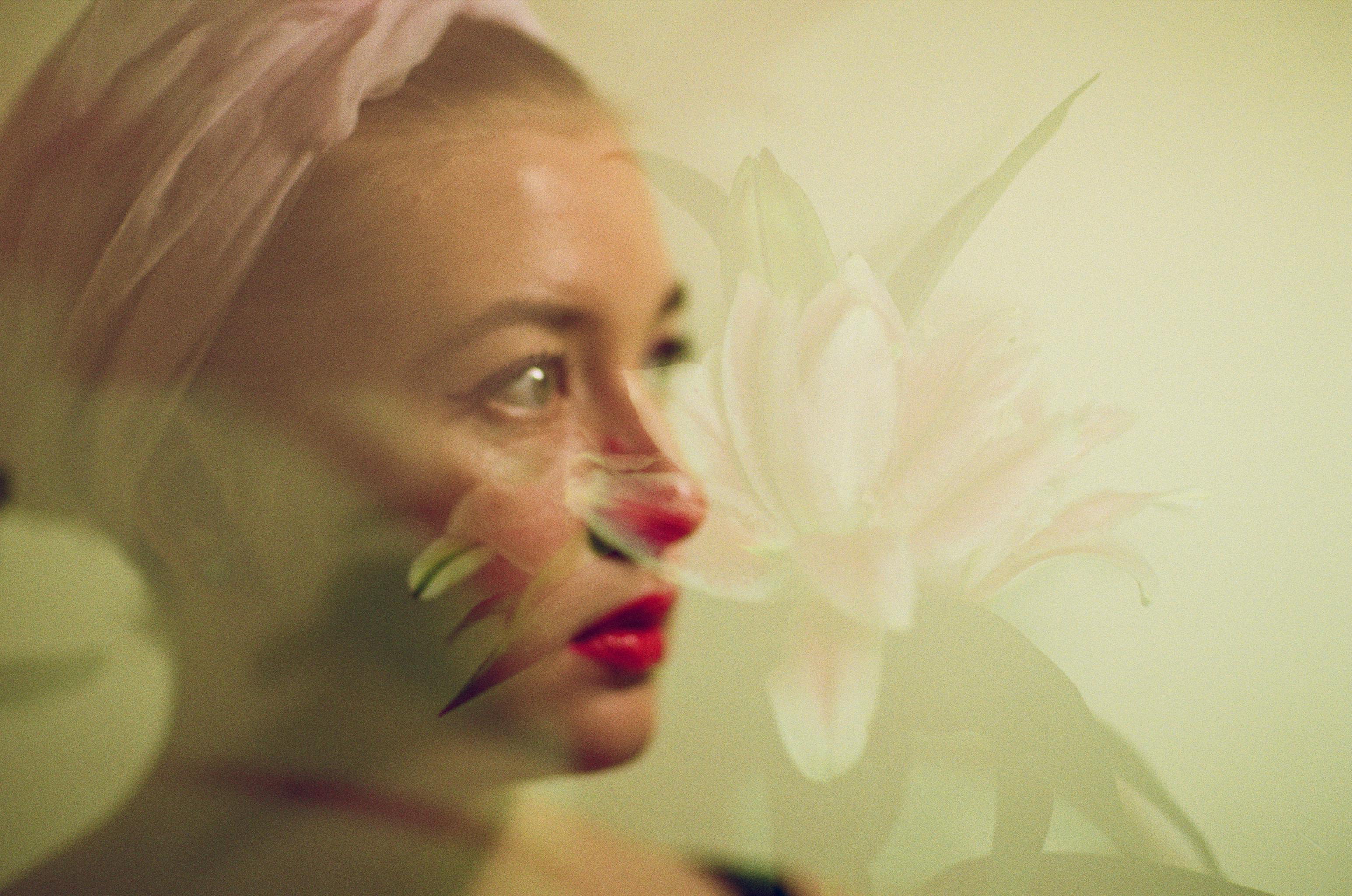 Creative double exposure portrait blending a woman's face with a floral motif, exuding a serene and artistic vibe.