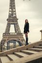 Man in Black Jacket Standing on Concrete Bridge Near Eiffel Tower