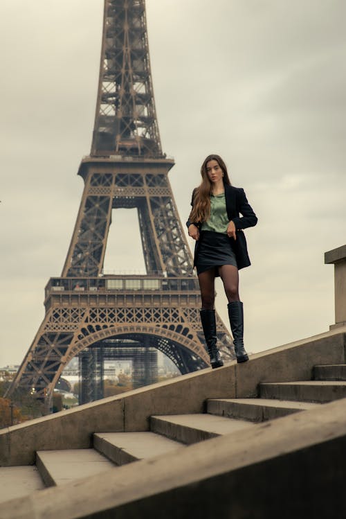 A Woman in Boots Standing Near the Eiffel Tower