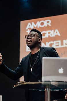 An inspiring speaker engaging an audience at a conference in Rio de Janeiro, Brazil, captured during a motivational session.