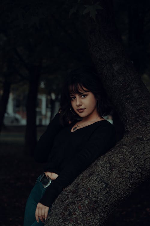 Free A Woman in Black Sweater Leaning on the Tree Stock Photo