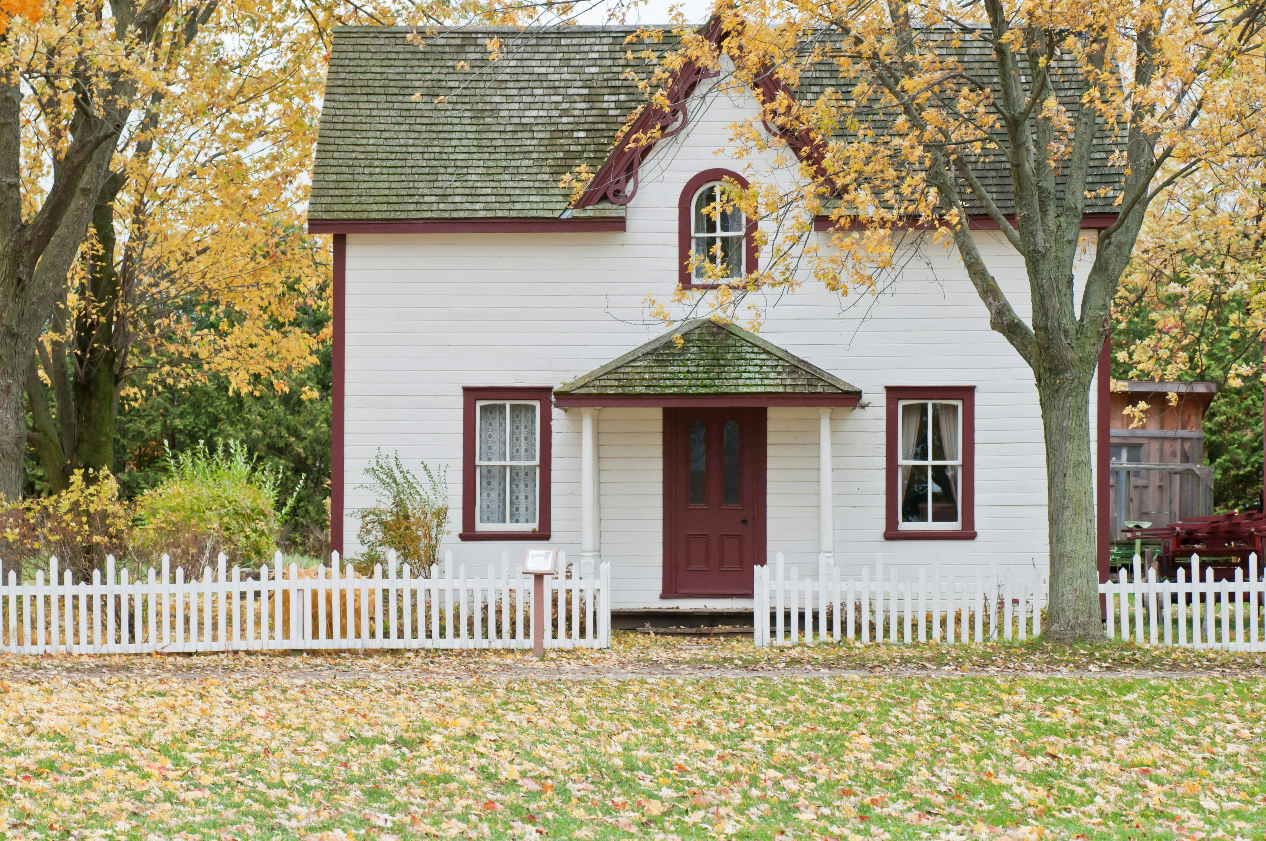 White and red wooden house with fence. | Photo: Pexels