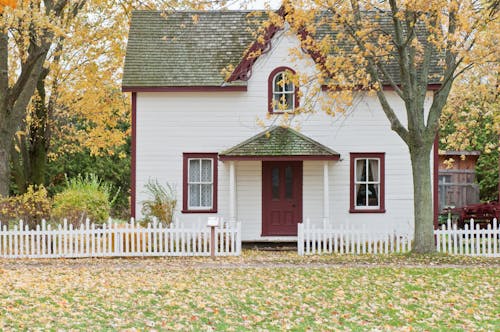 Casa De Madera Blanca Y Roja Con Valla