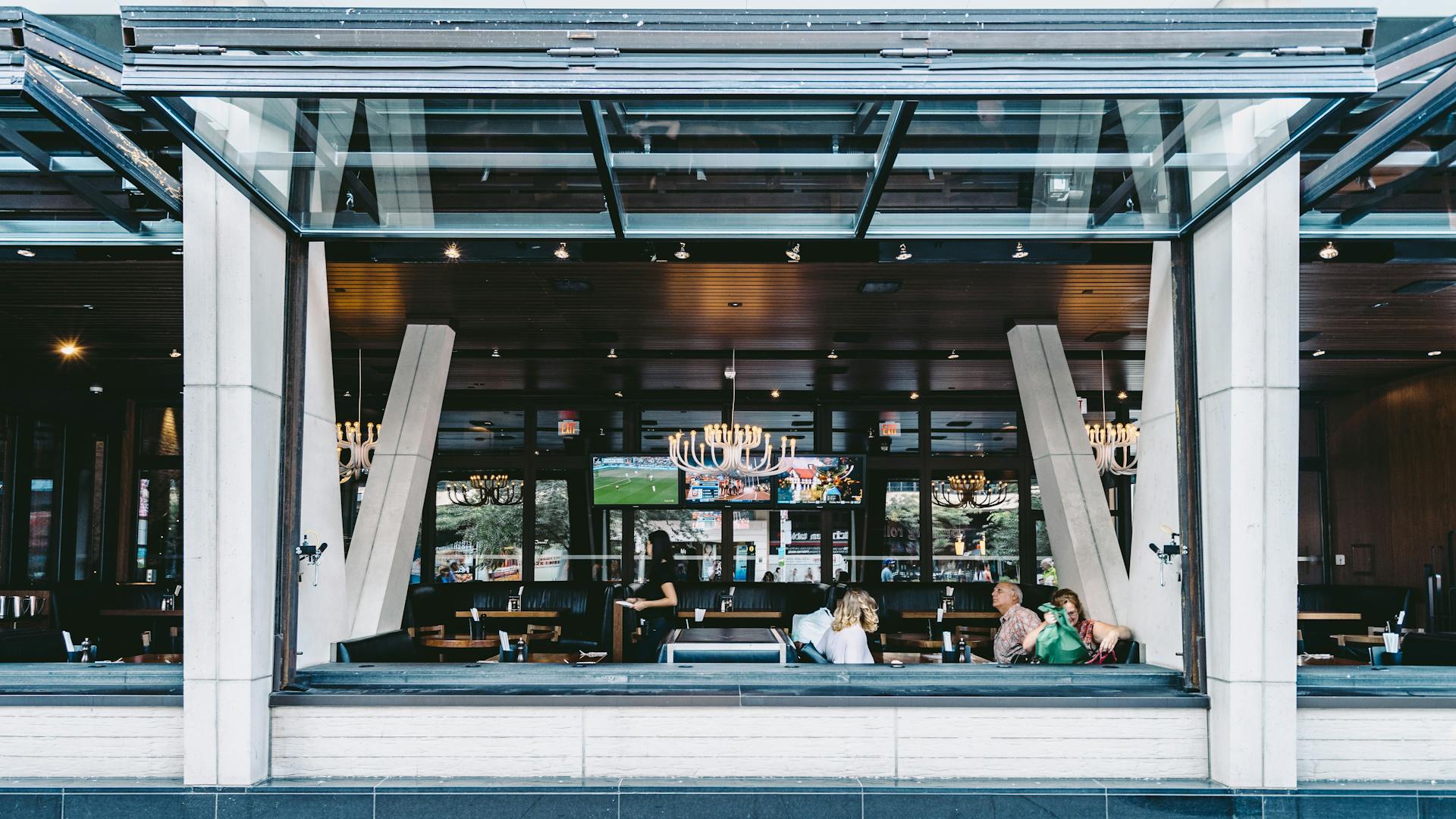 Open-air Toronto restaurant with contemporary design, patrons dining and chatting.