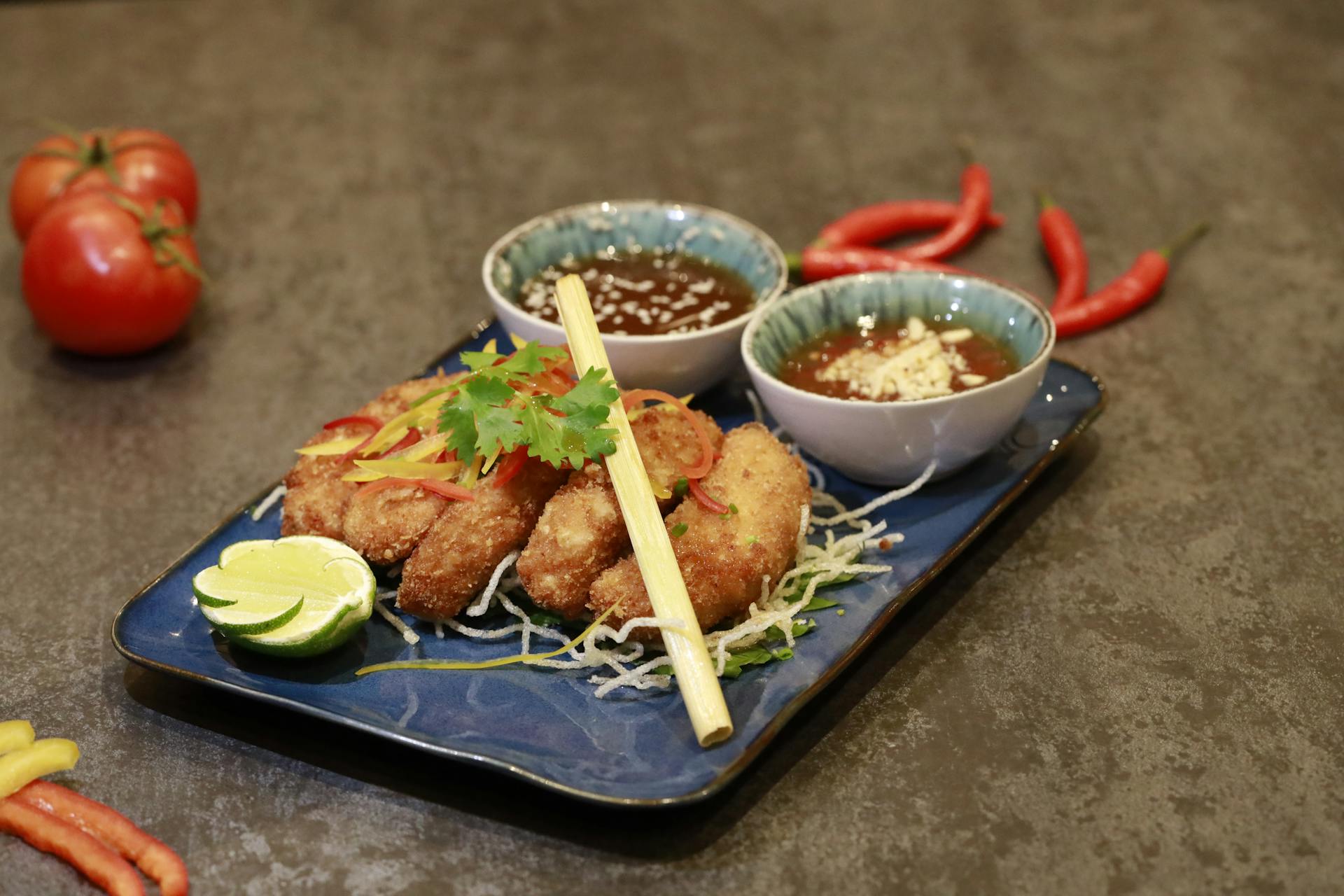 Delicious pork tonkatsu with variety of dips, beautifully presented on a blue ceramic plate.