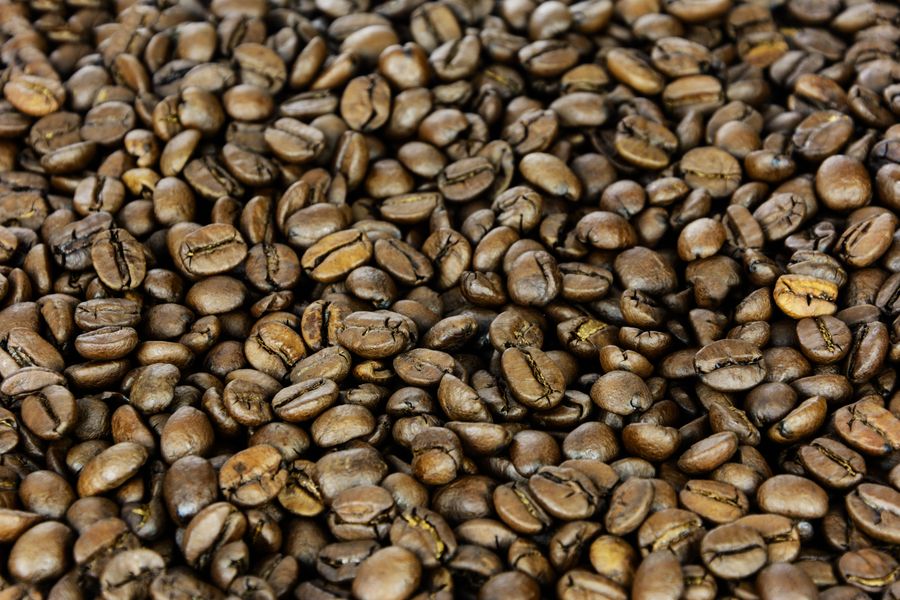 Rich close-up of dark roasted coffee beans filling the frame