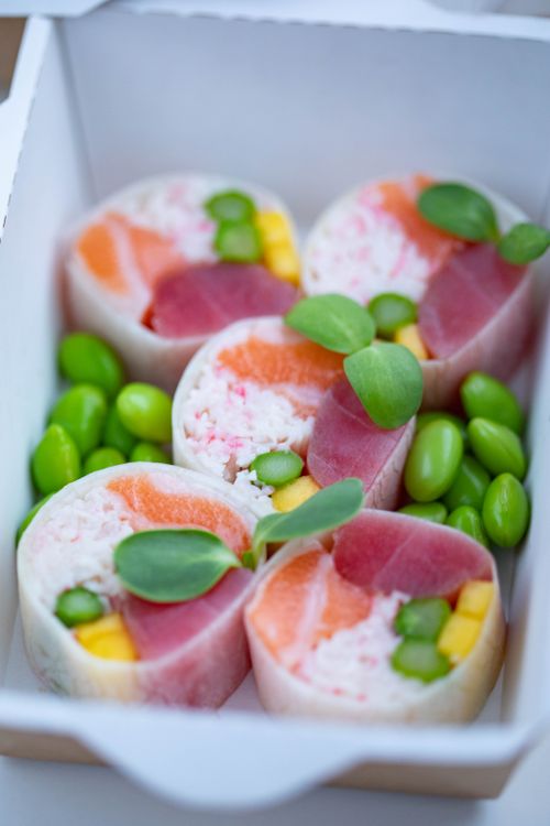 Free Vibrant sushi rolls with salmon, tuna, and edamame in a box. Stock Photo
