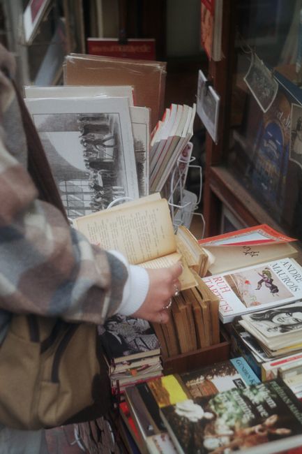 Person browsing books at a street shop in Istanbul, capturing the local literary culture.