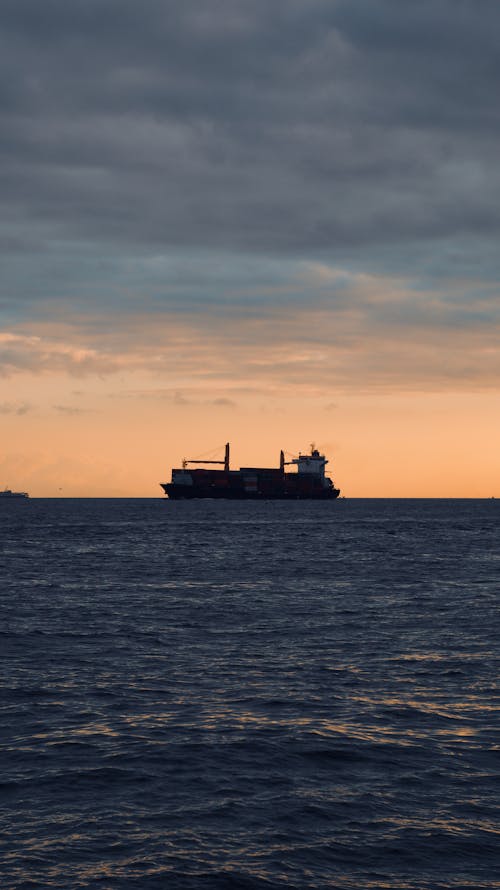 Silhouette of Ship on Sea during Dawn
