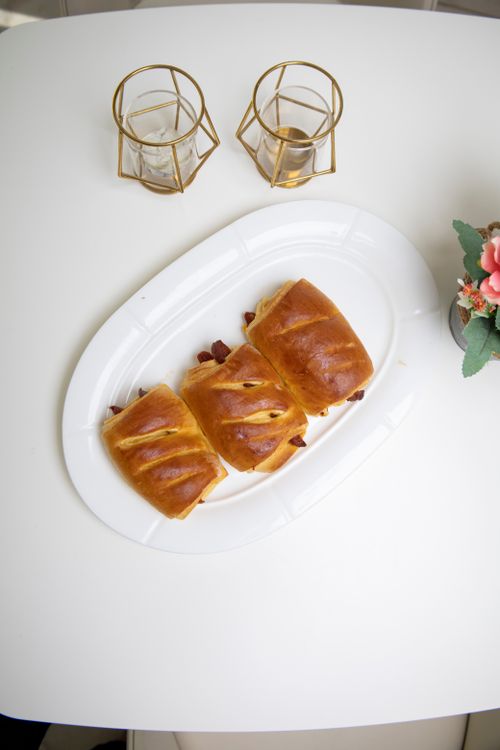 Free Delicious freshly baked pastries on a white plate with elegant candle holders, perfect for a cozy breakfast setting. Stock Photo