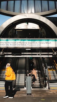 A bustling urban subway escalator in a London station with people commuting.
