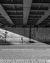 People Walking on the Sidewalk Under a Bridge